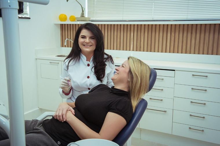 Dra. Daniela Cela atendendo uma paciente adulta na cadeira