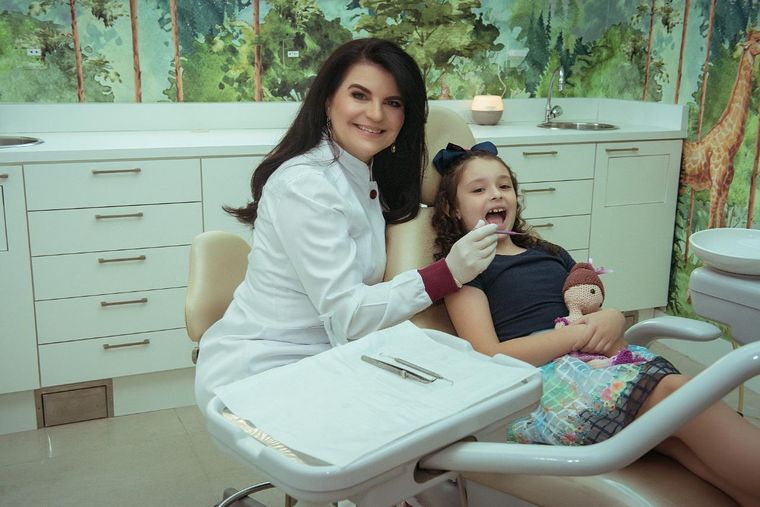 Dra. Daniela Cela atendendo uma criança na sala infantil