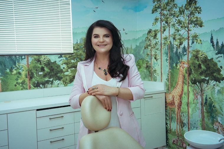 Dra. Daniela Cela junto à cadeira da sala infantil